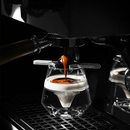 MHW-3BOMBER Espresso Cooling Ball über einem Glas unter der Espressomaschine
