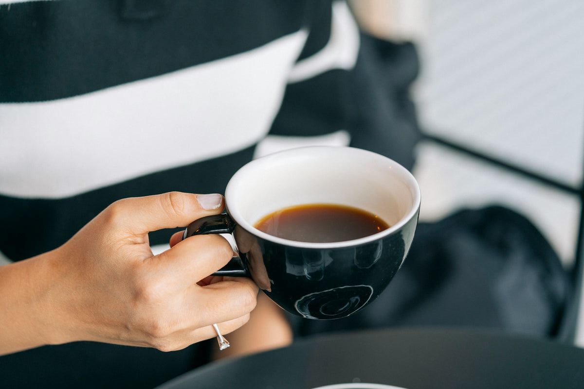 Frau hält Kaffeetasse in der Hand